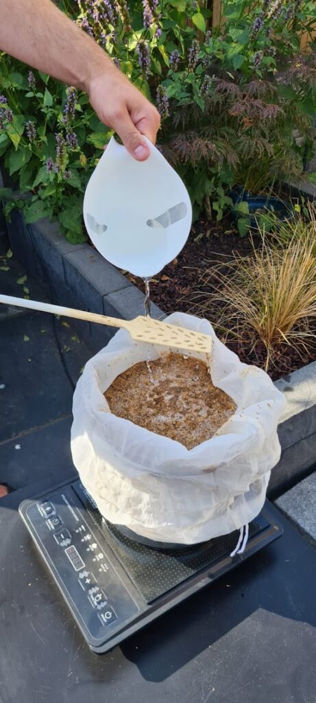 Mout spoelen in een open brouwzak tijdens een Brew in a Bag-proefbrouwsel voor Brouwpunt